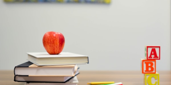 Students receiving educational materials and books in a classroom setting